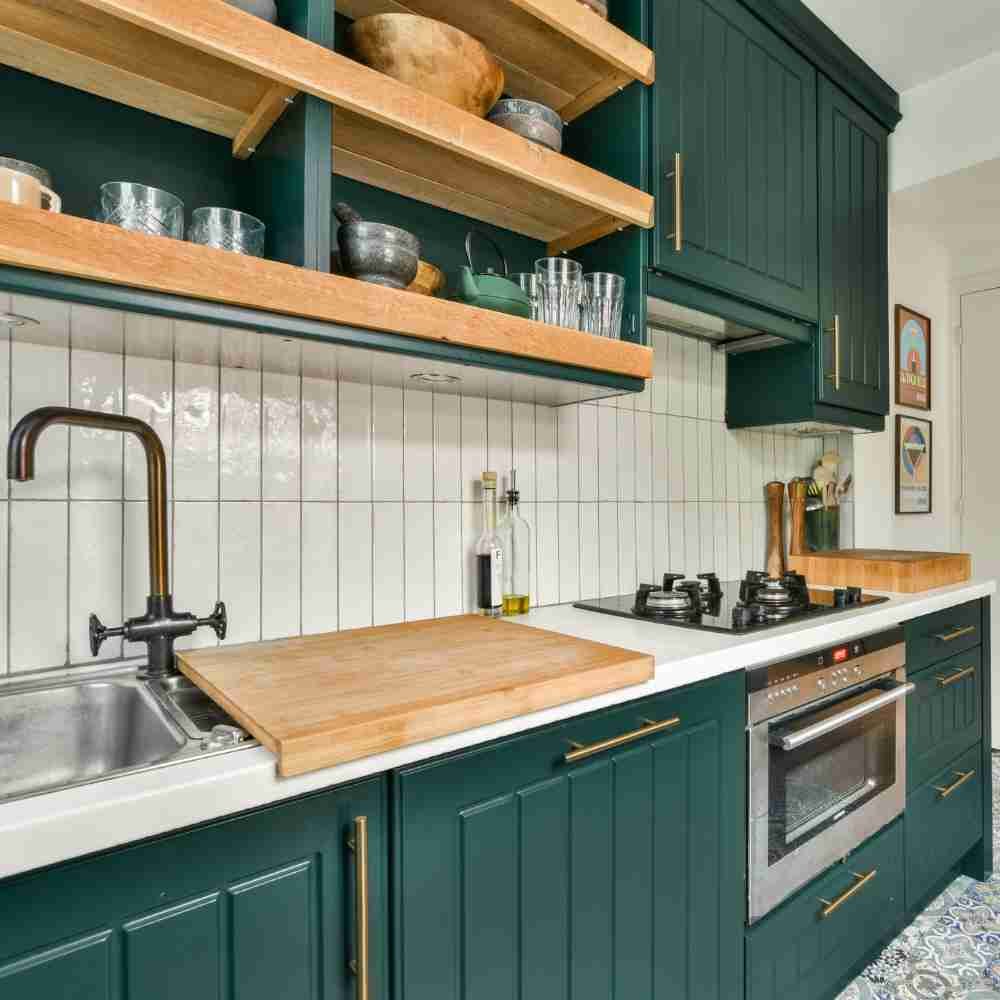 Illustrative dark green fitted kitchen with wood worktops and open shelving